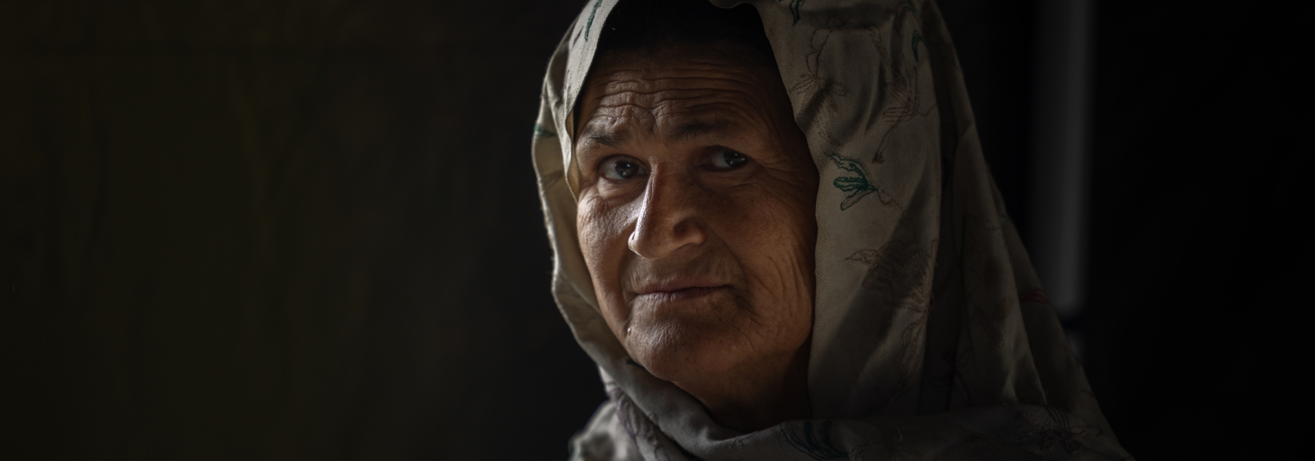 Jamale, a mother of six, returns to Afghanistan after twenty years only to discover her old home was destroyed, unsure where to find shelter. © Mina Nazari/IOM 2023