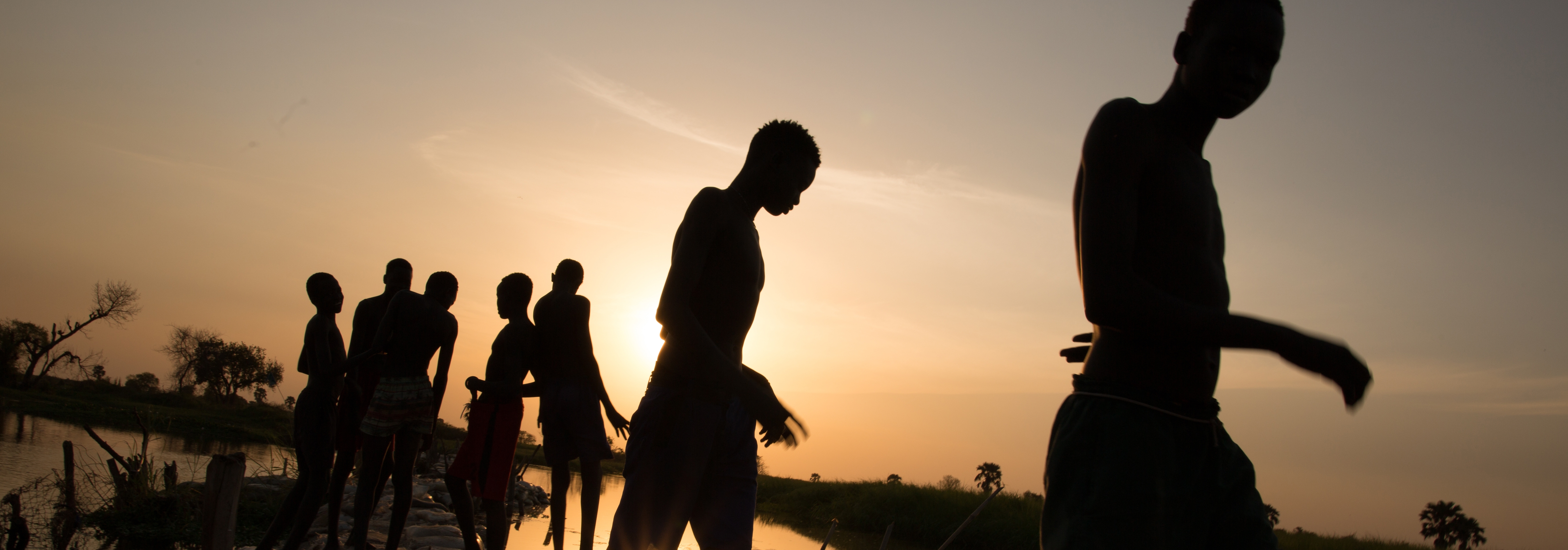 Youth that have been vital in building dikes in Bor, South Sudan following heavy flooding return home after a long day repairing and building dikes